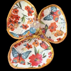 May include: A white ceramic mug with a black handle and the text "But First, Coffee" in a black, bold font. The mug is on a white surface. The mug is approximately 4 inches tall.