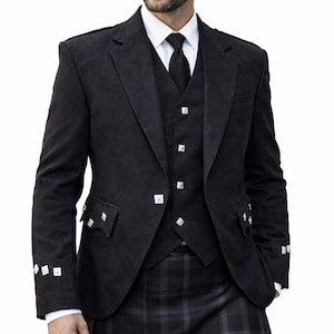 Puede incluir: Un traje escocés negro, que incluye chaqueta, chaleco y kilt. La chaqueta tiene botones cuadrados plateados y detalles de bolsillo. El kilt presenta un estampado de cuadros. El traje se lleva con camisa blanca y corbata negra.