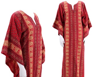 May include: A long red and gold patterned kaftan with a V-neck and long sleeves. The kaftan is made of a soft, flowing fabric and has a relaxed fit.