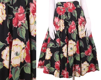 May include: A black midi skirt with a large floral print featuring red, pink, yellow, and green flowers. The skirt is full and has a gathered waist.