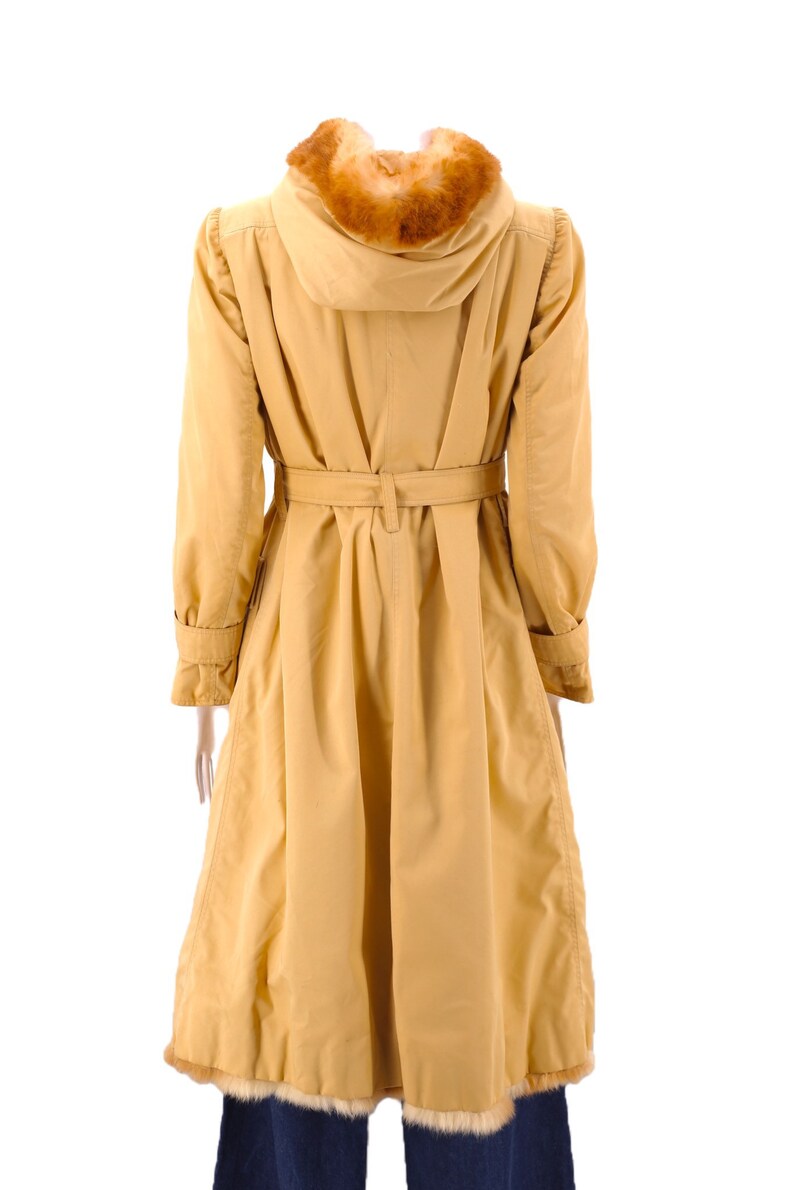 May include: A long, yellow raincoat with a fur-lined hood and a belt. The coat has a fitted waist and a flared skirt.