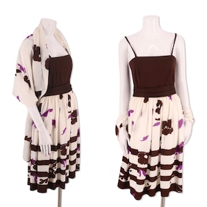 Puede incluir: Un vestido marrón y blanco con estampado floral morado y rayas marrones. El vestido tiene un corpiño marrón y una falda blanca con una faja marrón. El vestido está en un maniquí blanco.