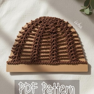 May include: A brown crochet hat pattern displayed on a tan background. The hat has a semi-circular shape with a detailed openwork design. The text "PDF Pattern" is visible in a rectangular box below the hat.