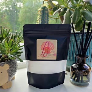 May include: A black resealable pouch with a white label. The label has a brown background with a red tree and the text "FLAVOR BOULEVARD" and "3000 CANDY FLAVORING".