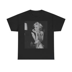 May include: A black short-sleeve t-shirt featuring a centered, rectangular black and white photographic print of Marilyn Monroe. The image shows a portrait of the subject with the text MONROE printed in a dark, subtle font across the center.