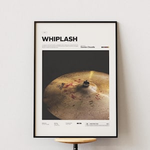May include: A black and white poster with the title "WHIPLASH" in bold white text. The poster features a close-up of a gold cymbal with red splatter marks. The text "Damien Chazelle" is printed below the title.