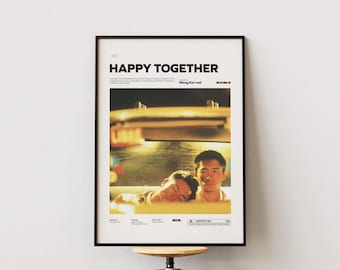 May include: Framed poster featuring the film "Happy Together." The poster has a black frame and displays the film's title in large, bold letters. The image shows two men, one sleeping, the other looking forward. The poster is mounted on a white wall.