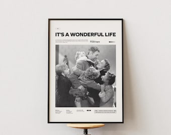 Op de afbeelding: Zwart-wit ingelijste poster van de film "It's a Wonderful Life". De poster toont een familie die elkaar omhelst. De titel van de film en de naam van de regisseur staan bovenaan. De poster hangt aan een witte muur.