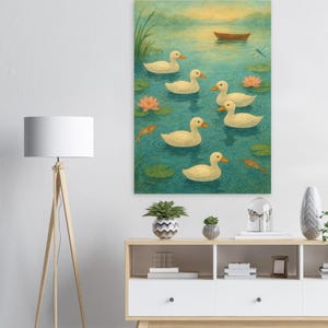 Op de afbeelding: Een ingelijste kunstdruk toont een serene vijverscène. Zeven witte eenden met oranje snavels zwemmen in turquoise water, omringd door waterlelies en roze bloemen. Een kleine bruine boot drijft in de verte, met een libelle erboven.
