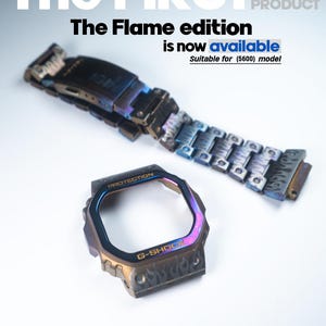 Könnte beinhalten: Ein metallisches Uhrengehäuse mit Flammen-Design. Das Gehäuse ist irisierend mit blauen, violetten und goldenen Farbtönen. Der Text "PROTECTION" und "G-SHOCK" ist auf dem Gehäuse sichtbar. Der Text "The Flame edition is now available" wird über dem Gehäuse angezeigt. Der Text "Suitable for (5600) model" wird unter dem Gehäuse angezeigt.