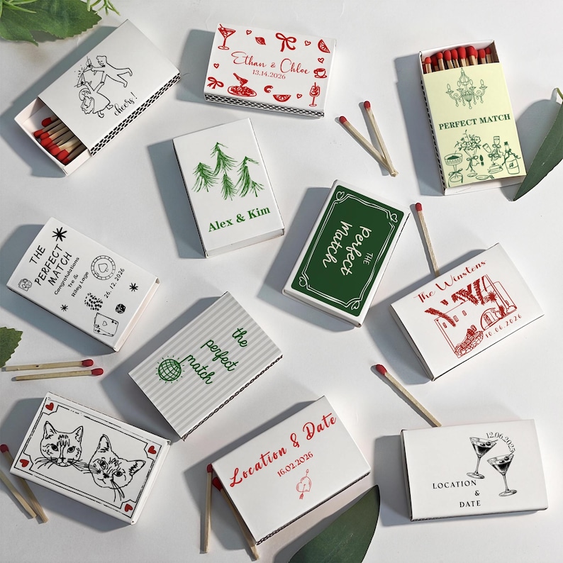 Puede incluir: Una colecci&oacute;n de cajas de cerillas decorativas con varios dise&ntilde;os y texto. Algunas cajas presentan ilustraciones de gatos, c&oacute;cteles y gr&aacute;ficos tem&aacute;ticos de bodas. El texto incluye nombres, fechas y frases como "Perfect Match."