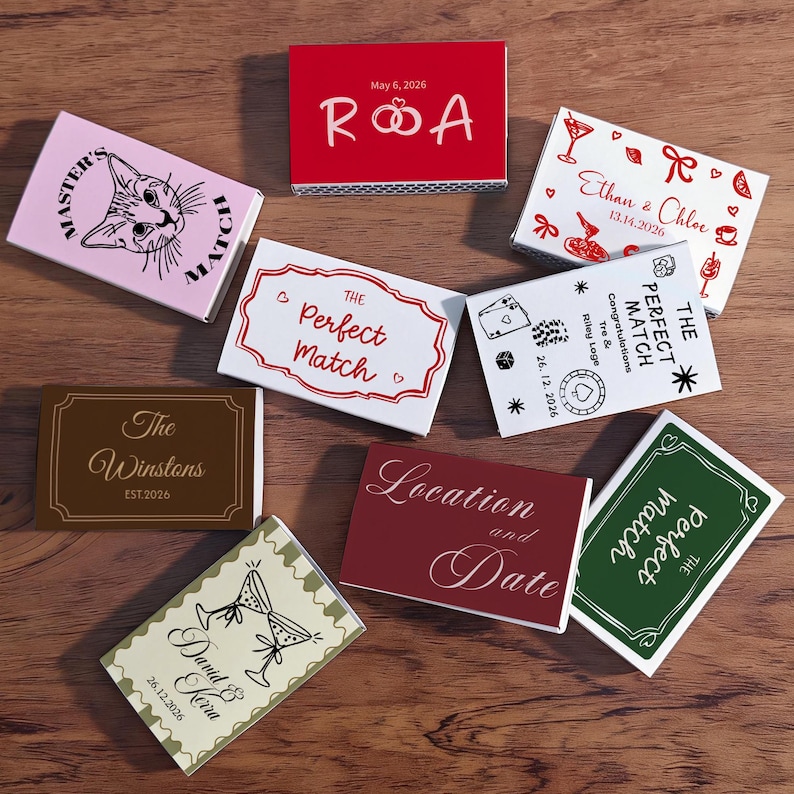 Puede incluir: Una colecci&oacute;n de cajas de cerillas decorativas con varios dise&ntilde;os y texto. Algunas cajas presentan temas relacionados con bodas, incluyendo nombres, fechas y la frase "The Perfect Match". Otras cajas tienen ilustraciones de un gato, c&oacute;cteles y otros gr&aacute;ficos.