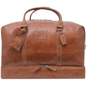 Adjustable and removable genuine leather strap with brass hardware on tan duffle bag