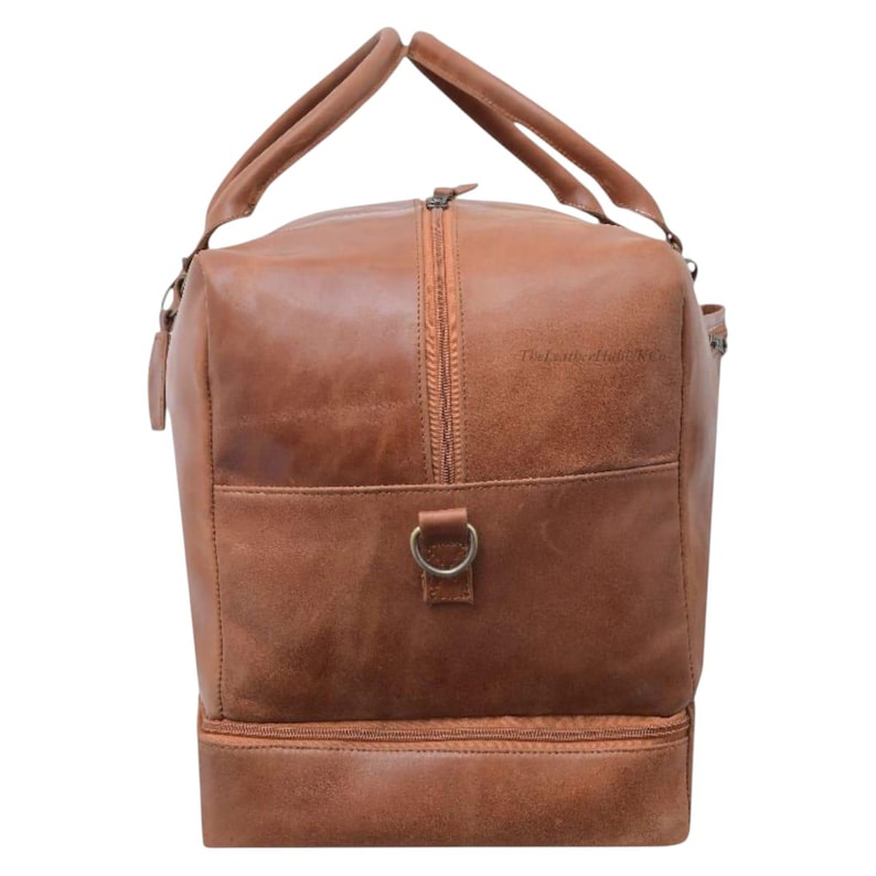 Side view of genuine tan leather duffle bag showing spacious design and detachable strap