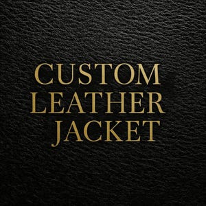 May include: Close-up of a black leather texture with the words "CUSTOM LEATHER JACKET" in gold. The text is in a bold serif font and is centrally positioned. The leather has a subtle, textured appearance.