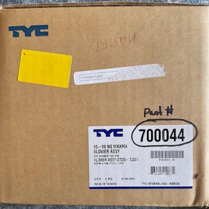 Puede incluir: Una caja de cartón marrón con una etiqueta blanca que dice "TYC" y "95-99 NS MAXMA BLOWER ASSY". La etiqueta también incluye el número de pieza "700044".