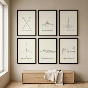 May include: Six framed art prints with black line drawings on a cream background. The prints feature rowing-related illustrations and motivational phrases such as "Find Your Stroke" and "Pull with Purpose". The frames are black.