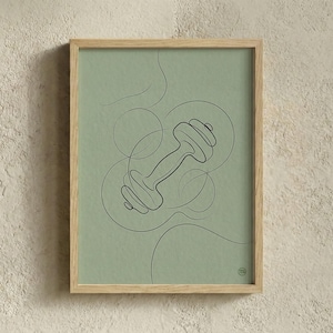 May include: A framed art print featuring a minimalist line drawing of a dumbbell on a sage green background. The artwork is encased in a natural wood frame, offering a modern aesthetic. The design includes abstract lines and circles.