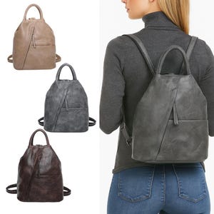 Könnte beinhalten: Drei Kunstleder-Rucksäcke in Beige, Grau und Braun. Jeder Rucksack hat einen oberen Griff, verstellbare Träger und eine Vordertasche mit vertikalem Reißverschluss. Eine Person trägt einen grauen Rucksack.