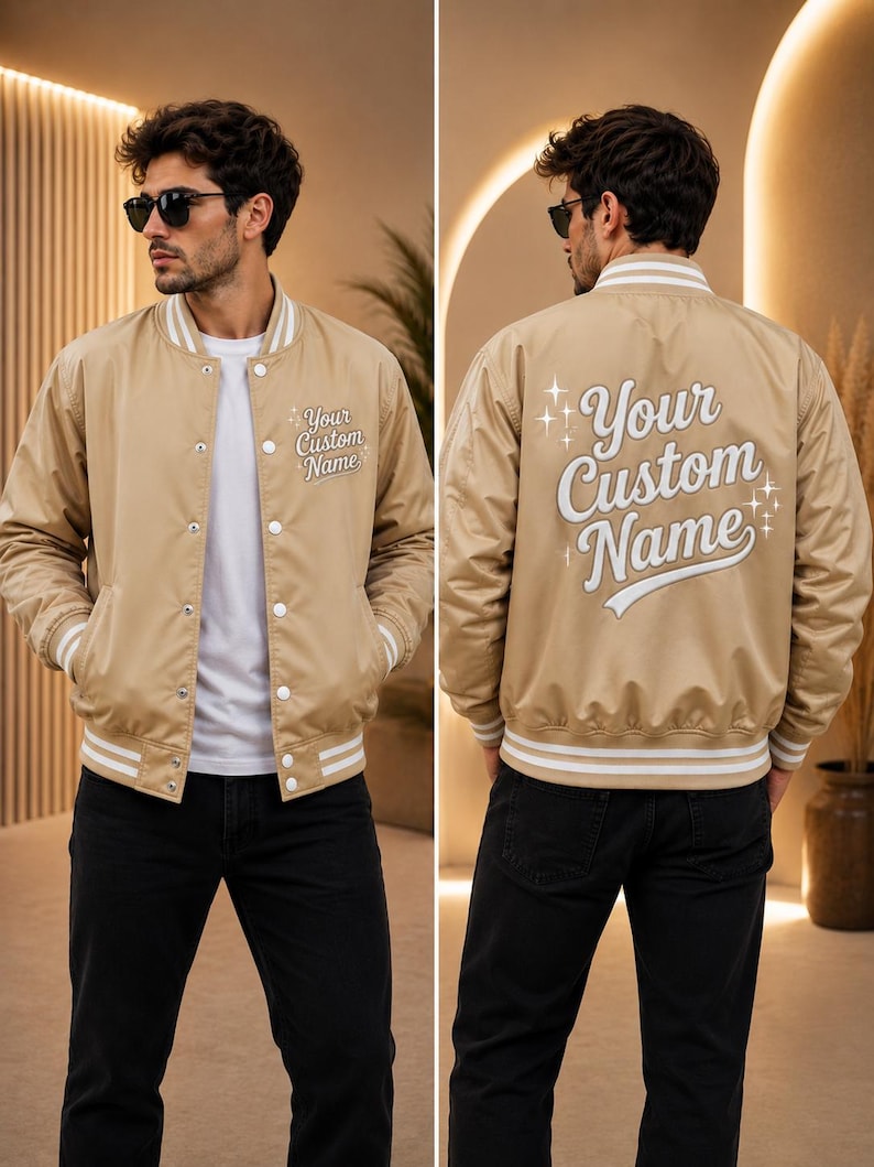 May include: A beige varsity jacket with white striped ribbed trim on the collar, cuffs, and hem. The front features the text Your Custom Name, and the back displays the same text in a larger font with decorative star accents on both sides.