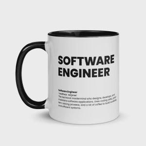 May include: White ceramic mug with a black handle and interior. The mug features the text "SOFTWARE ENGINEER" in bold black letters. Below the text is a definition of a software engineer.