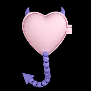 Pode incluir: Uma caixa rosa em forma de coração com chifres e cauda de diabo roxos. A caixa tem um design articulado e uma superfície texturizada. A cauda é feita de formas esféricas conectadas e termina em uma seta roxa.