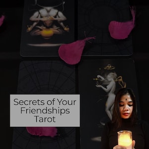 May include: A collection of tarot cards with illustrations and the text "Secrets of Your Friendships Tarot." The cards are black with detailed artwork. Pink feathers are scattered around the cards. A person is holding a lit candle.