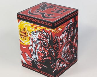 May include: A red and black box with a detailed illustration. The box features a red background with black and white character illustrations. The top of the box has red text and a black border. The box is square and sits on a white surface.