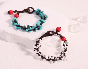 May include: Two handmade bracelets. One features turquoise-colored stone chips and red beads on a brown cord. The other bracelet has white stone chips and red beads on a brown cord. Both bracelets have a knotted closure.