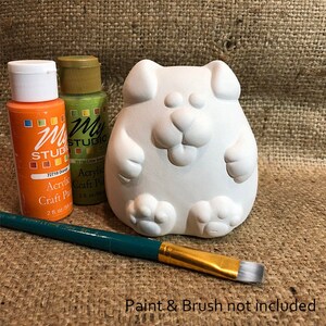 Può includere: Figurina di cane in ceramica bianca con impronte di zampe in rilievo e un viso sorridente. Sono inclusi due flaconi di vernice acrilica per l'artigianato, uno arancione e uno verde. È incluso anche un pennello. Vernice e pennello non inclusi.