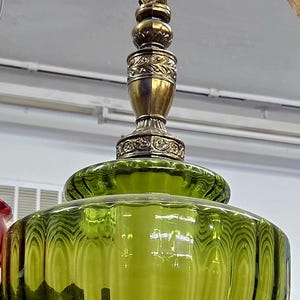 Peut inclure: Suspension luminaire vintage en verre vert avec une base et des accents en métal couleur laiton. L'abat-jour est arrondi et nervuré. Le luminaire est suspendu par un cordon et possède une douille pour ampoule standard.