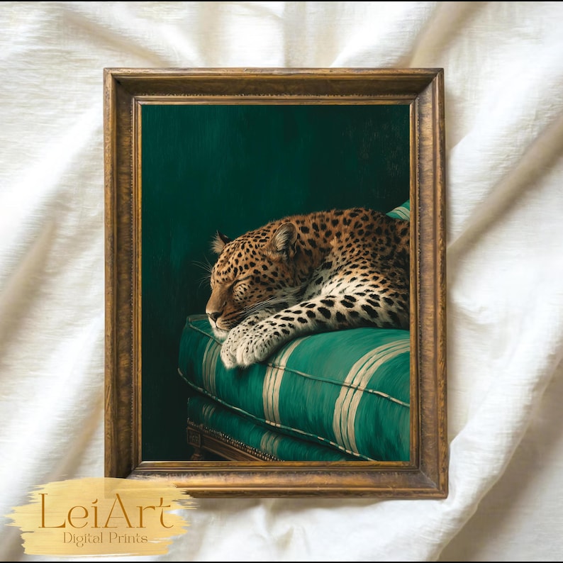 May include: A framed print featuring a sleeping leopard resting on a green striped cushion. The artwork has a dark green background and is enclosed in a gold-colored frame. The print is labeled "LeiArt Digital Prints".