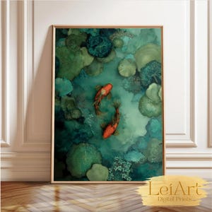 Puede incluir: Una impresión artística enmarcada con dos peces koi naranjas nadando en un estanque con nenúfares verdes y plantas acuáticas. La obra de arte tiene un efecto acuarela con tonos verdes y azules. La impresión se muestra sobre un suelo de madera.
