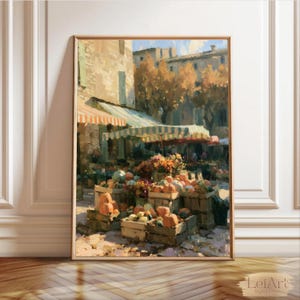 May include: An oil painting print depicting a vibrant outdoor market scene with wooden crates filled with orange pumpkins and colorful produce, set beneath striped awnings in front of stone buildings with golden autumn trees in the background.