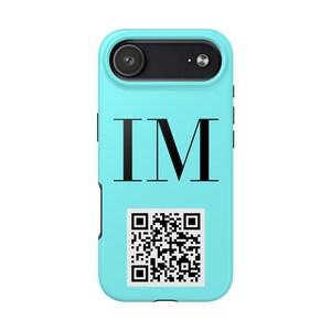 May include: A light blue phone case with a black camera lens and the letters "IM" in black. A QR code is printed below the letters. The phone case is designed to fit a smartphone.
