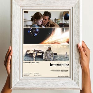 Puede incluir: Un póster de película enmarcado para la película Interstellar, una película de Christopher Nolan. El póster presenta tres imágenes de la película: un primer plano de dos personajes, una nave espacial volando a través de un agujero de gusano y un personaje con un traje espacial de pie en un planeta. El póster también incluye el título de la película, el director, el reparto y el texto "El amor es lo único que sabemos que trasciende las dimensiones del tiempo y del espacio." y "BSO by Hans Zimmer".