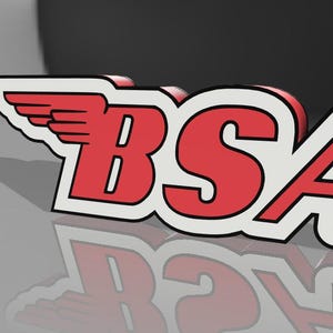 May include: A 3D logo featuring the letters "BSA" in red with a white border, and a wing design. The logo is set against a grey and black gradient background, with a reflection below.