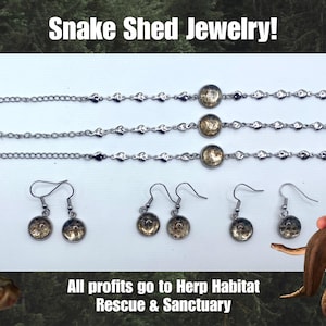 Op de afbeelding: Snake Shed Sieraden! De afbeelding toont drie zilveren armbanden en drie paar oorbellen. Elk sieraad heeft een cirkelvormige bedel met een uniek ontwerp. De tekst "Snake Shed Jewelry!" en "All profits go to Herp Habitat Rescue & Sanctuary" zijn ook zichtbaar.