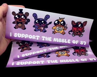 May include: A rectangular sticker with a light purple gradient background featuring four cartoon characters: a brown bear with a microphone, a purple rabbit with a guitar, a yellow chick with a bib, and a red fox. The text reads I SUPPORT THE NIBBLE OF 87.
