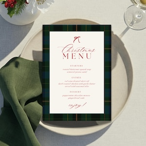 May include: A Christmas menu card with a green and black plaid border. The menu features a red bow and the words "Christmas Menu" in elegant script. The menu includes starters, entree, and dessert options.