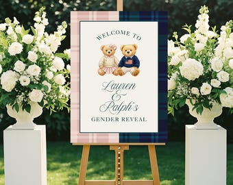 May include: A wooden easel displays a sign with a plaid border, featuring two teddy bears and the text "Welcome to Lauren & Ralph's Gender Reveal." The sign is surrounded by white floral arrangements.