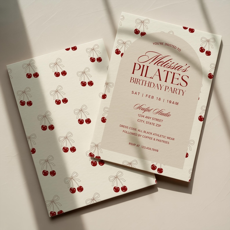May include: Two cream-colored invitations with a cherry pattern. One invitation is open, revealing text that reads "Melissa's Pilates Birthday Party" with event details. The cherry design includes red cherries and light brown bows.