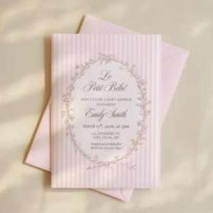 May include: A baby shower invitation with a pink and white striped design. The invitation includes the text "Le Petit Bébé" and details for Emily Smith's baby shower, including the date, time, and location. A pink envelope is behind the invitation.