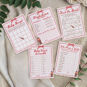 以下が含まれることがあります： 赤と白のギンガムチェックの縁取りが付いたベビーシャワーゲームカードのコレクションです。「ベビービンゴ」、「予測とアドバイス」、「ゲストを探す」などのタイトルが特徴です。各カードには装飾用のリボンとコカ・コーラのボトルのグラフィックが付いています。