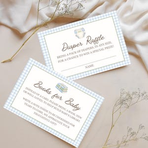 May include: Two rectangular cards with a light blue and white gingham border. One card reads Diaper Raffle, Bring a pack of diapers, in any size, for a chance to win a special prize! Name. The other reads Books for Baby, Instead of a card, please bring a book, new or well-loved, to help build baby's library. Write a note inside to be cherished for years to come. We appreciate your thoughtful gift!