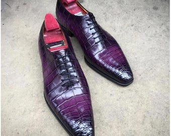 May include: A pair of purple crocodile leather dress shoes with lace-up fastenings. The shoes have a pointed toe and a low heel.