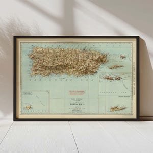 Puede incluir: Mapa antiguo enmarcado de Puerto Rico, con cartografía detallada y sombreado de relieve. El mapa incluye la topografía de la isla, carreteras y aguas circundantes, con texto que indica el Mar Caribe y las Islas Vírgenes. El mapa está enmarcado en un borde negro.