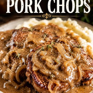 May include: Two seared pork chops topped with a thick brown onion gravy and fresh thyme sprigs, served on a plate with mashed potatoes. The text "Smothered PORK CHOPS" is displayed in large white and gold lettering at the top of the image.
