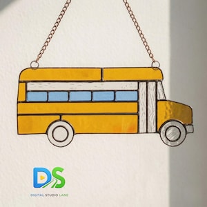 May include: A stained glass school bus in yellow, blue, and white, suspended by a copper chain. The bus features rectangular windows and a detailed design, perfect for home decor or as a gift. The logo "DS DIGITAL STUDIO LANE" is visible at the bottom.