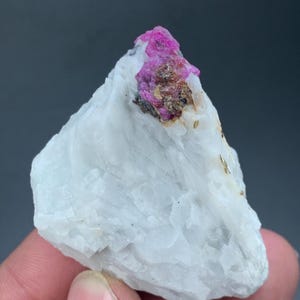 Pode incluir: Uma caneca de cerâmica branca com uma alça preta e o texto "But First, Coffee" em preto, em negrito. A caneca está sobre uma superfície branca. A caneca tem aproximadamente 10 cm de altura.